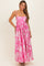 woman wearing a pink floral maxi dress with spaghetti straps and a flared skirt