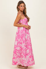 woman wearing a pink floral maxi dress with spaghetti straps and a flowy silhouette