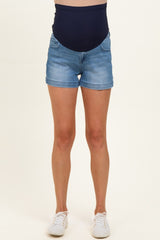 woman wearing light blue maternity shorts with a dark blue over-the-bump band and white sneakers