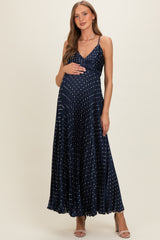 woman wearing a navy blue maternity maxi dress with silver polka dots and a baby bump visible