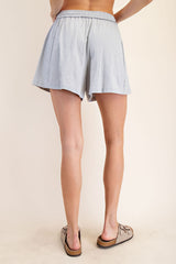 woman wearing light gray casual shorts with an elastic waistband, viewed from the back