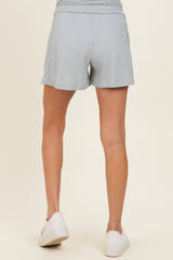 woman wearing light gray maternity shorts, view from the back, showing a comfortable fit and casual style