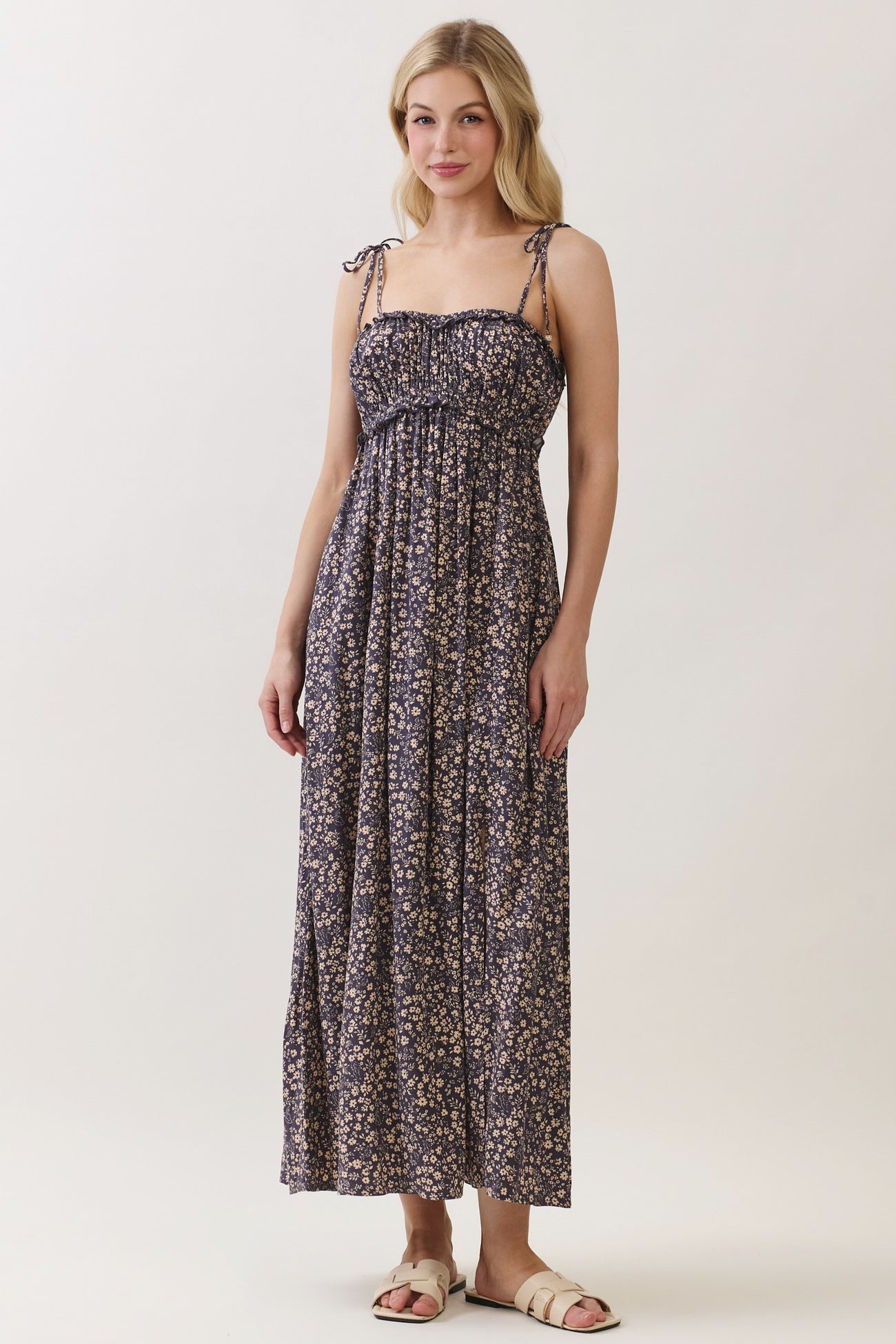 woman wearing a navy floral maxi dress with adjustable straps and a smocked bodice