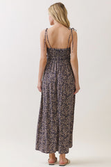 woman wearing a navy floral maxi dress with adjustable tie straps and smocked back detail