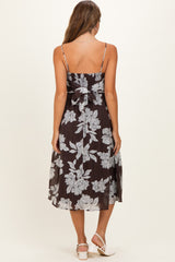woman wearing a dark floral print maternity dress with thin straps and a bow detail at the back