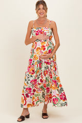 woman wearing a floral maternity maxi dress with a tiered skirt and holding her baby bump