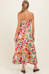 woman wearing a floral print maternity maxi dress with a smocked back and adjustable straps, showcasing a flowing skirt