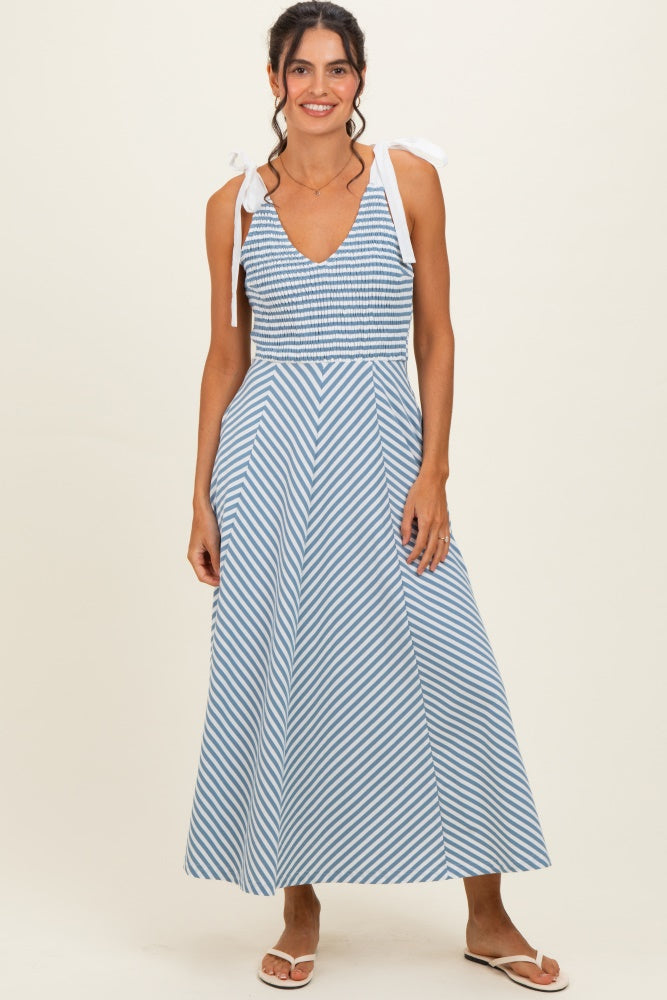 woman wearing a blue and white striped maxi dress with tie shoulder straps and a fitted bodice