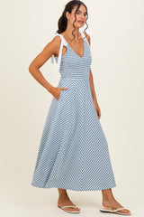 woman wearing a blue and white striped maxi dress with tie straps and pockets