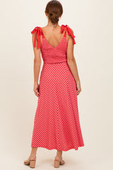 woman wearing a red and white striped maxi dress with smocked bodice and tie shoulder straps, shown from the back