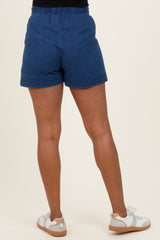 woman wearing dark blue maternity shorts with crocheted detail at the hem and casual white sneakers
