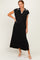 woman wearing a black maxi dress with a white collar and side slit, standing with one hand on her hip