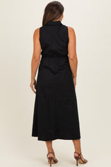 woman wearing a black sleeveless maternity dress with an elastic waistband, showing the back view