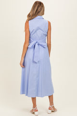 woman wearing a light blue sleeveless maternity dress with a tied waist detail, view from the back