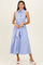 woman wearing a sleeveless light blue button-up dress with a tie waist detail and a flowing skirt