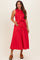 woman wearing a red sleeveless maternity dress with a tied waist and button-down front