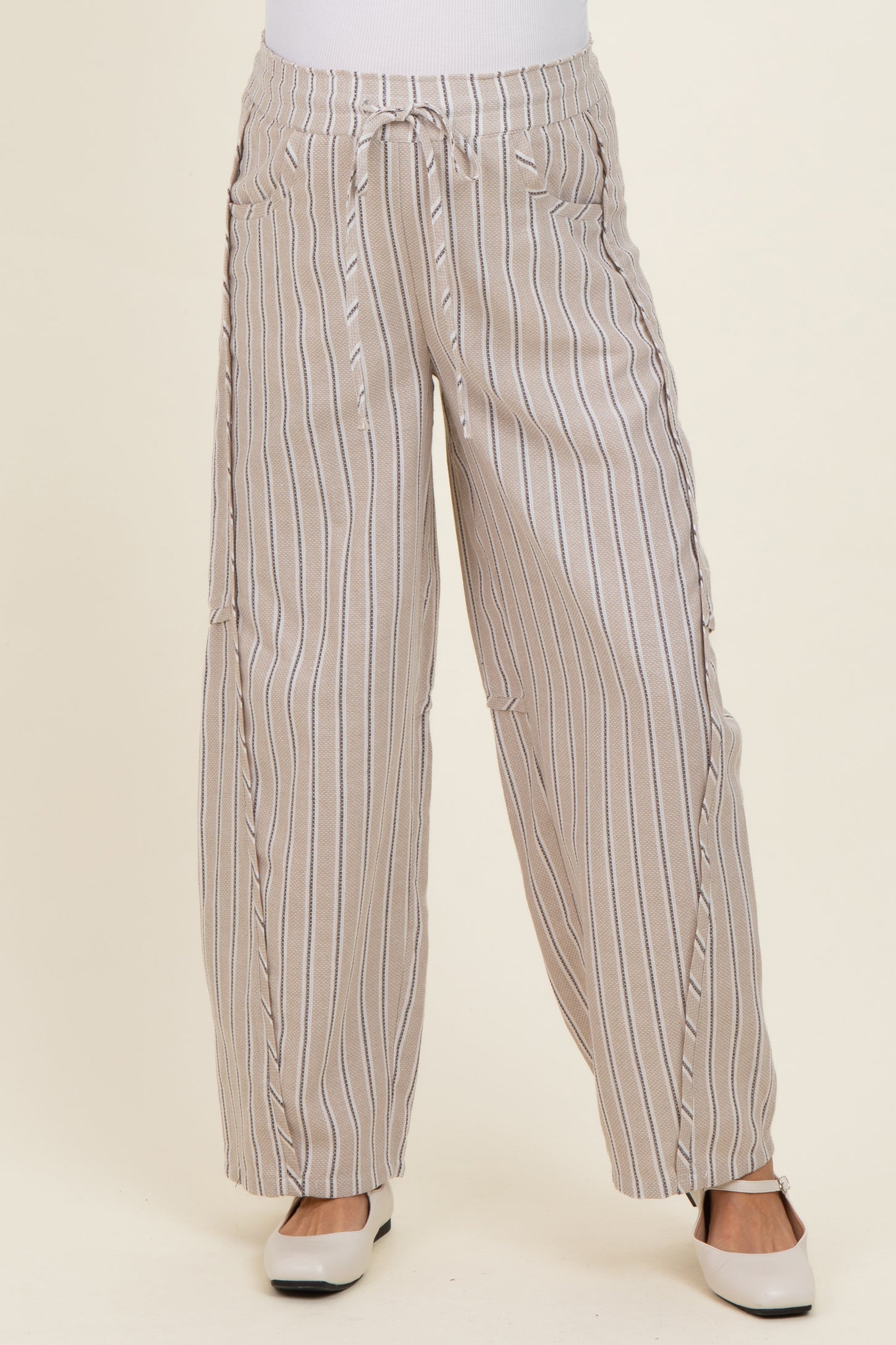 woman wearing beige and white striped maternity wide-leg pants with drawstring waist