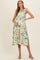 woman wearing a floral maternity dress with tie straps and holding her baby bump