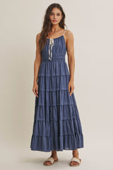 woman wearing a navy blue tiered maxi dress with a smocked bodice and adjustable straps