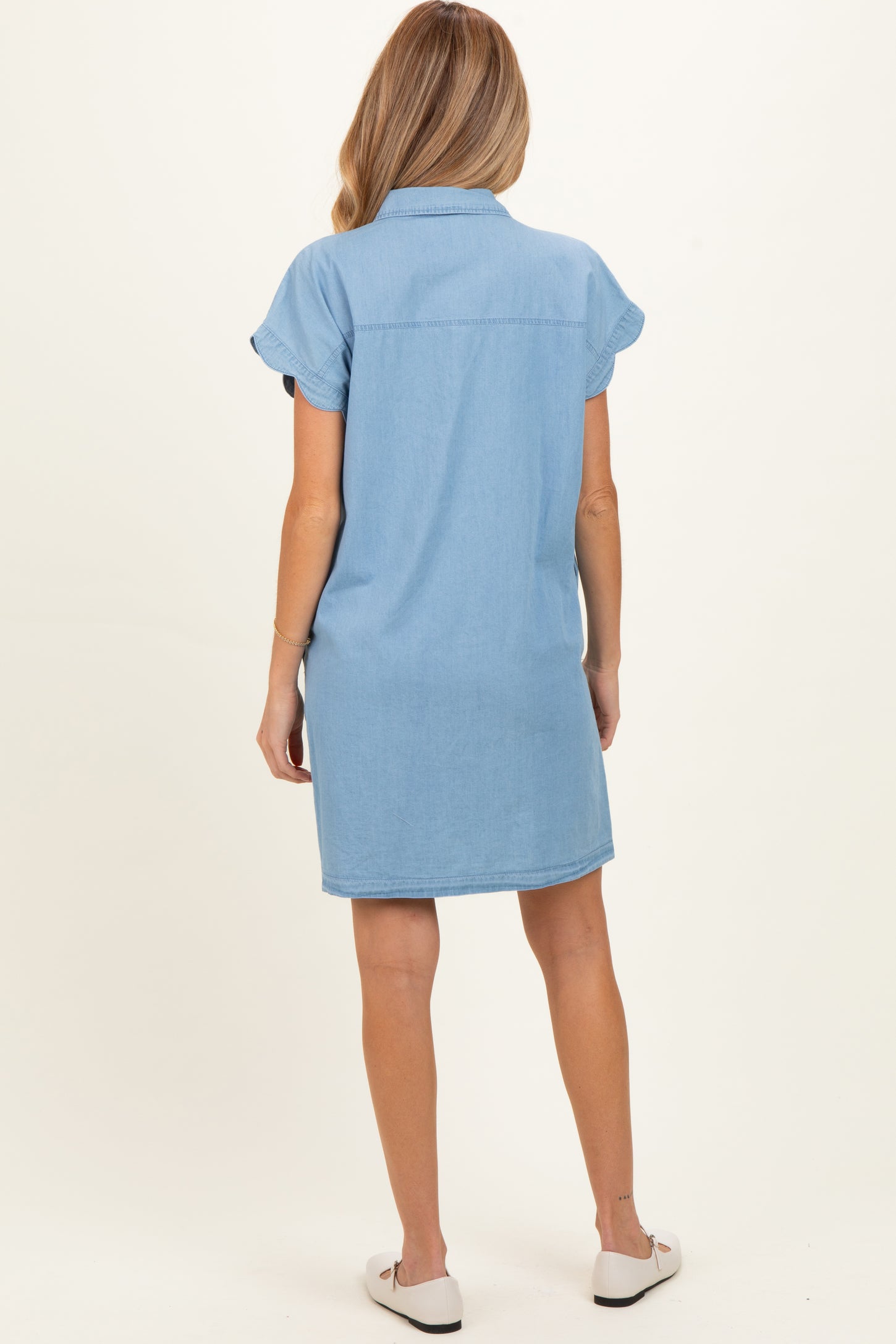 woman wearing a light blue denim maternity shirt dress with short sleeves, shown from the back