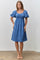 woman wearing a blue smocked dress with puff sleeves and a square neckline