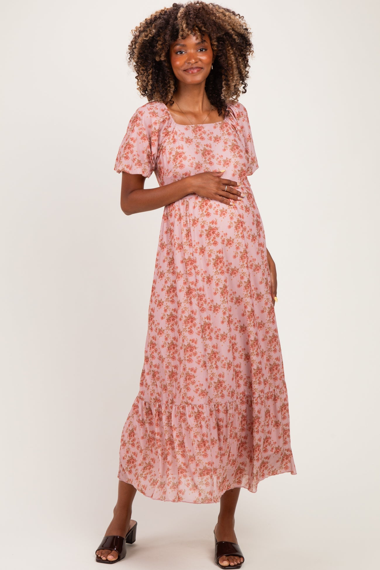 woman wearing a pink floral maternity maxi dress with short sleeves and a baby bump visible