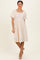 woman wearing a cream floral puff sleeve dress with a square neckline and knee-length hem