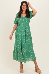 woman wearing a green floral maxi dress with puff sleeves and a tiered skirt