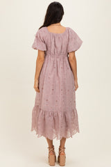 woman wearing a lilac boho style midi dress with puff sleeves and a tiered skirt from the back
