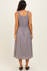 woman wearing a gray and white striped midi dress with ruffled straps and smocked waist, viewed from the back