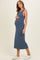 woman wearing a blue ribbed maternity dress and holding her baby bump
