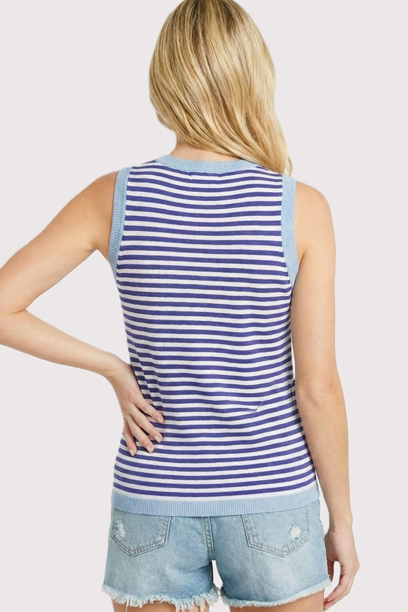 woman wearing a blue and white striped sleeveless knit top with light blue shoulder details and denim shorts