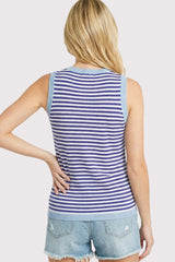 woman wearing a blue and white striped sleeveless knit top with light blue shoulder details and denim shorts