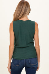 woman wearing a dark green sleeveless maternity top with a relaxed fit and back view visible