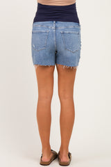 woman wearing light blue maternity denim shorts with a frayed hem, showing the back view and a fitted waistband