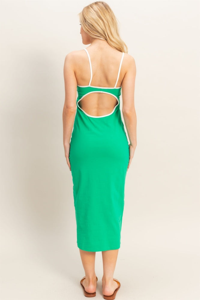 woman wearing a green midi dress with a white trim and an open back detail