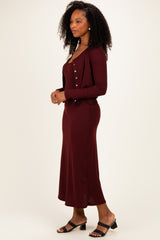 woman wearing a burgundy ribbed maxi dress with a matching button-up cardigan and black heeled sandals