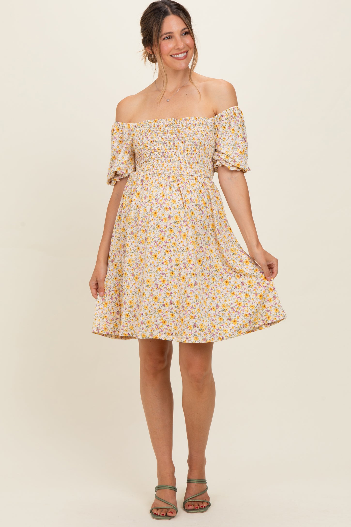 woman wearing a floral off-the-shoulder maternity dress with a smocked bodice and short puff sleeves