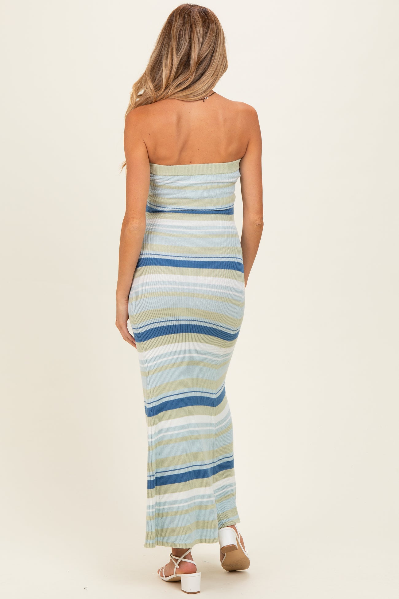 woman wearing a light blue and green striped strapless maternity maxi dress from the back