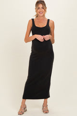 woman wearing a black sleeveless maternity maxi dress and displaying her baby bump