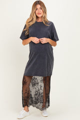 woman wearing a dark gray maternity dress with a sheer black lace overlay and white sneakers, baby bump not visible