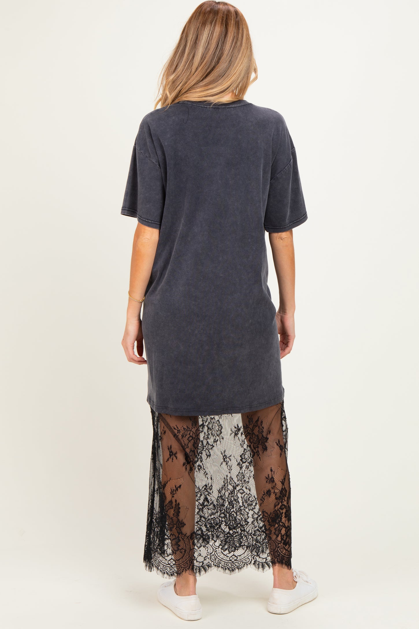 woman wearing a charcoal gray maternity oversized t-shirt dress with a sheer black lace overlay at the bottom