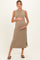woman wearing a beige sleeveless maternity dress and holding her baby bump