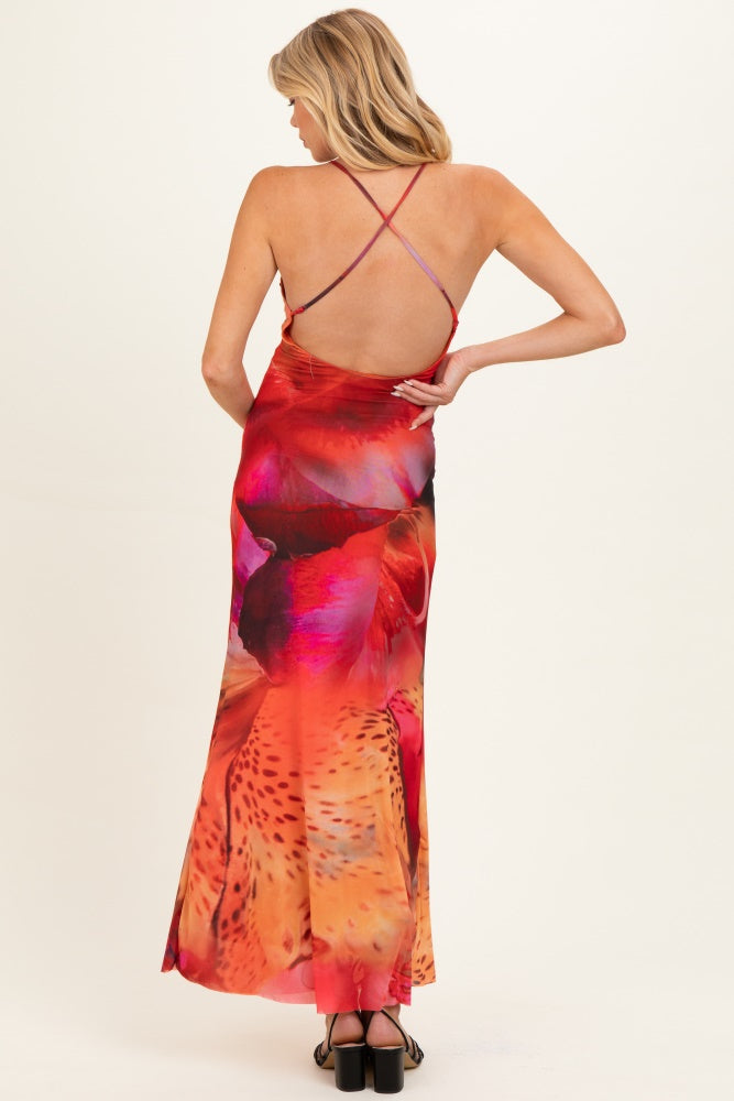 woman wearing a vibrant floral print maternity dress with a low back and crisscross straps