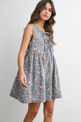 woman wearing a blue floral sleeveless dress with lace-up detail and a flared silhouette