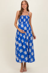 woman wearing a blue floral maternity dress with a flowy fit and a visible baby bump