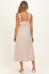 woman wearing a light beige maternity maxi dress with ruffle straps and a smocked waist, showing her back