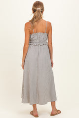 woman wearing a black and white striped maternity maxi dress with a smocked bodice and adjustable straps