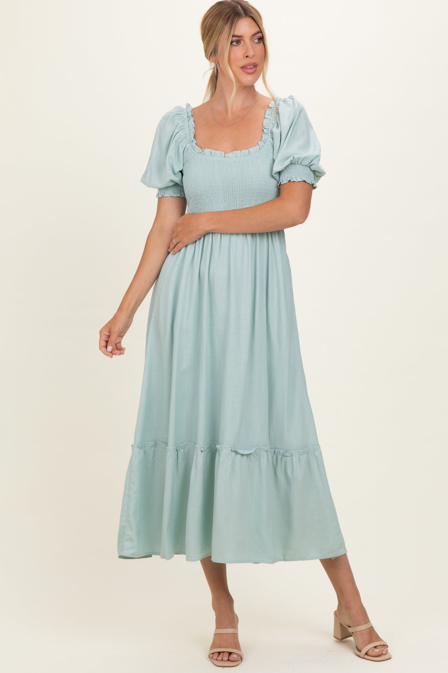 woman wearing a light mint green midi dress with puff sleeves and ruffle hem