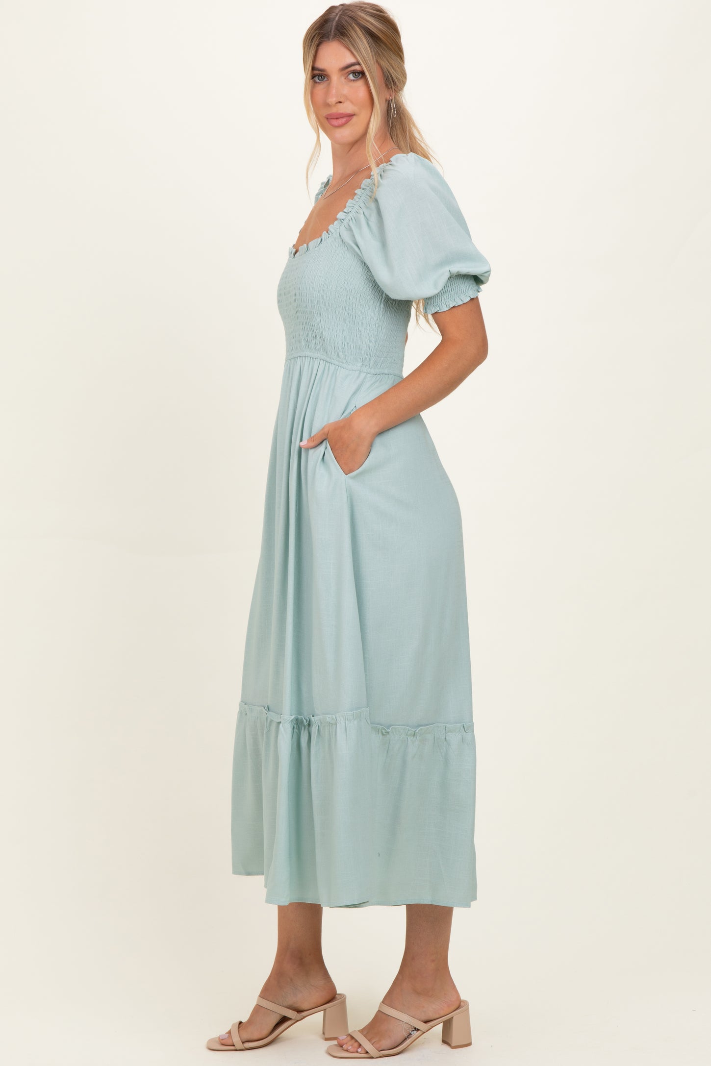 woman wearing a light blue puff sleeve maxi dress with smocked bodice and pockets